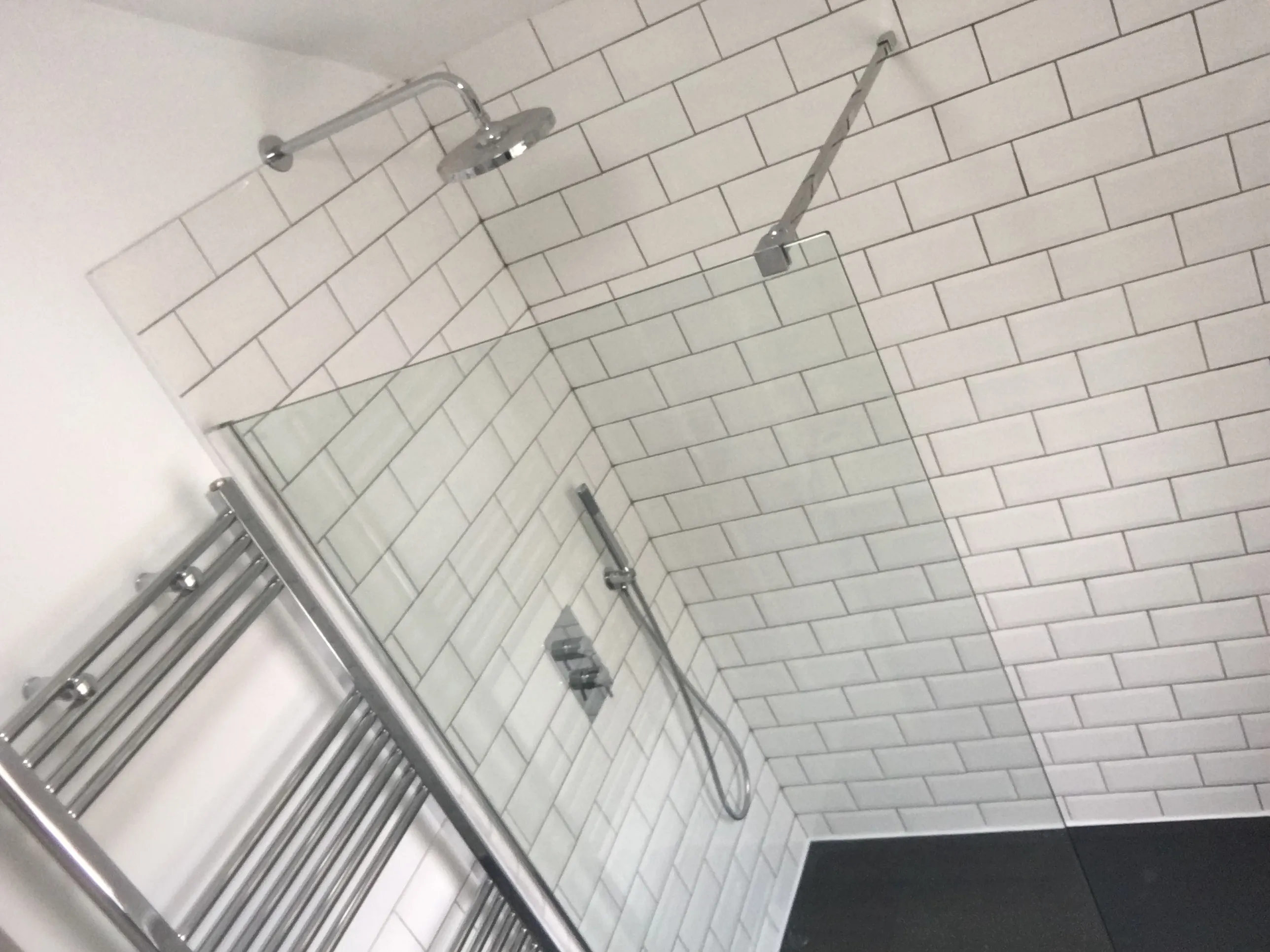Finished bathroom shower with white metro tiles and chrome fittings