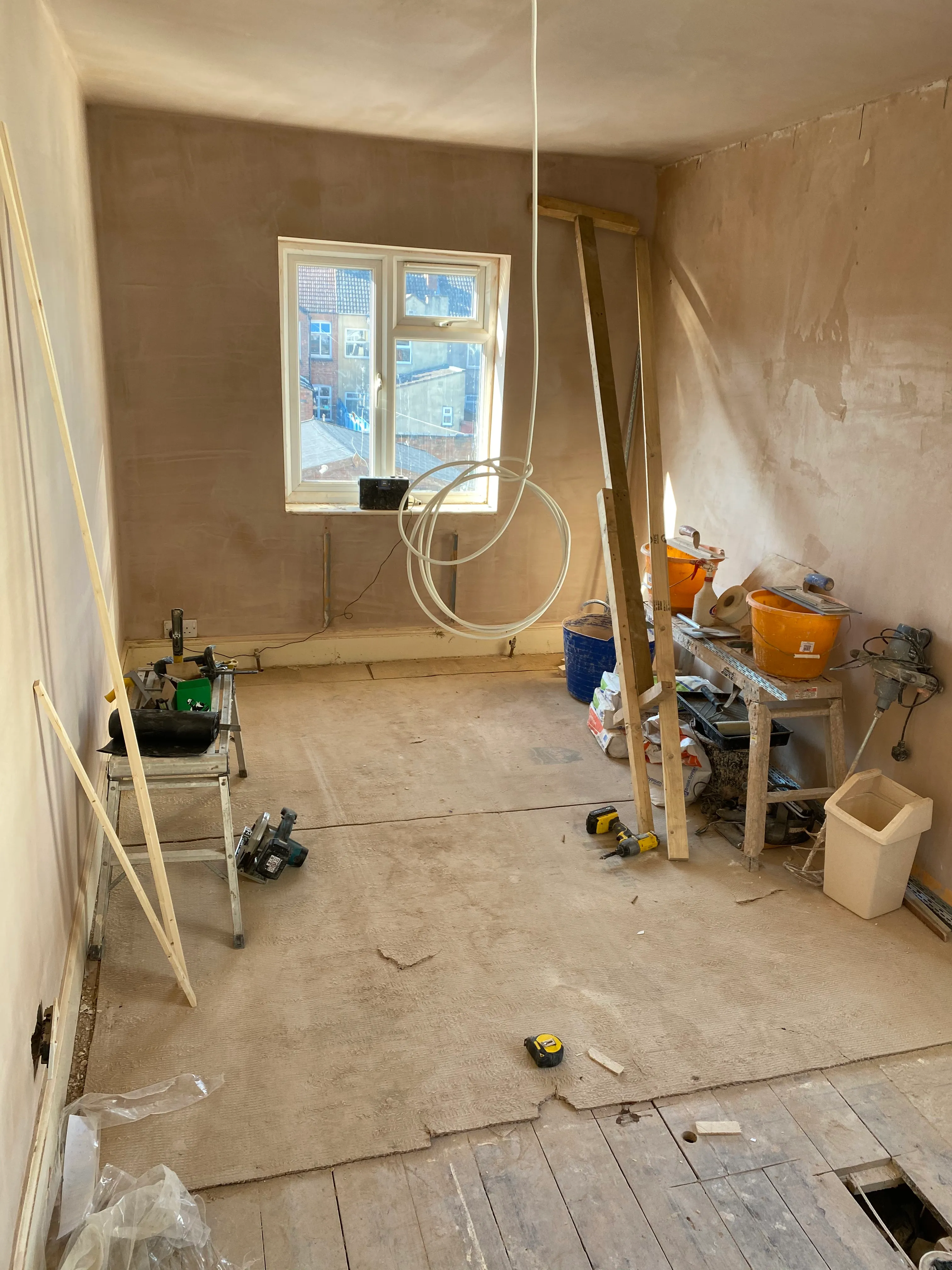 HMO conversion bedroom during construction with unfinished plastered walls