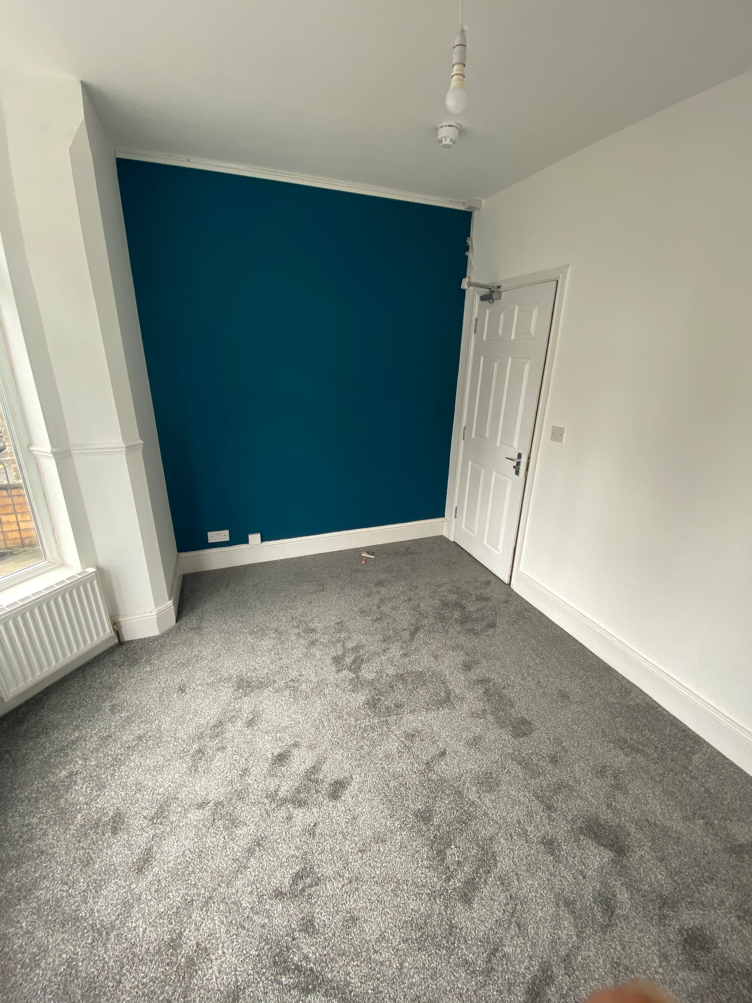 Finished HMO room with blue feature wall and grey carpet