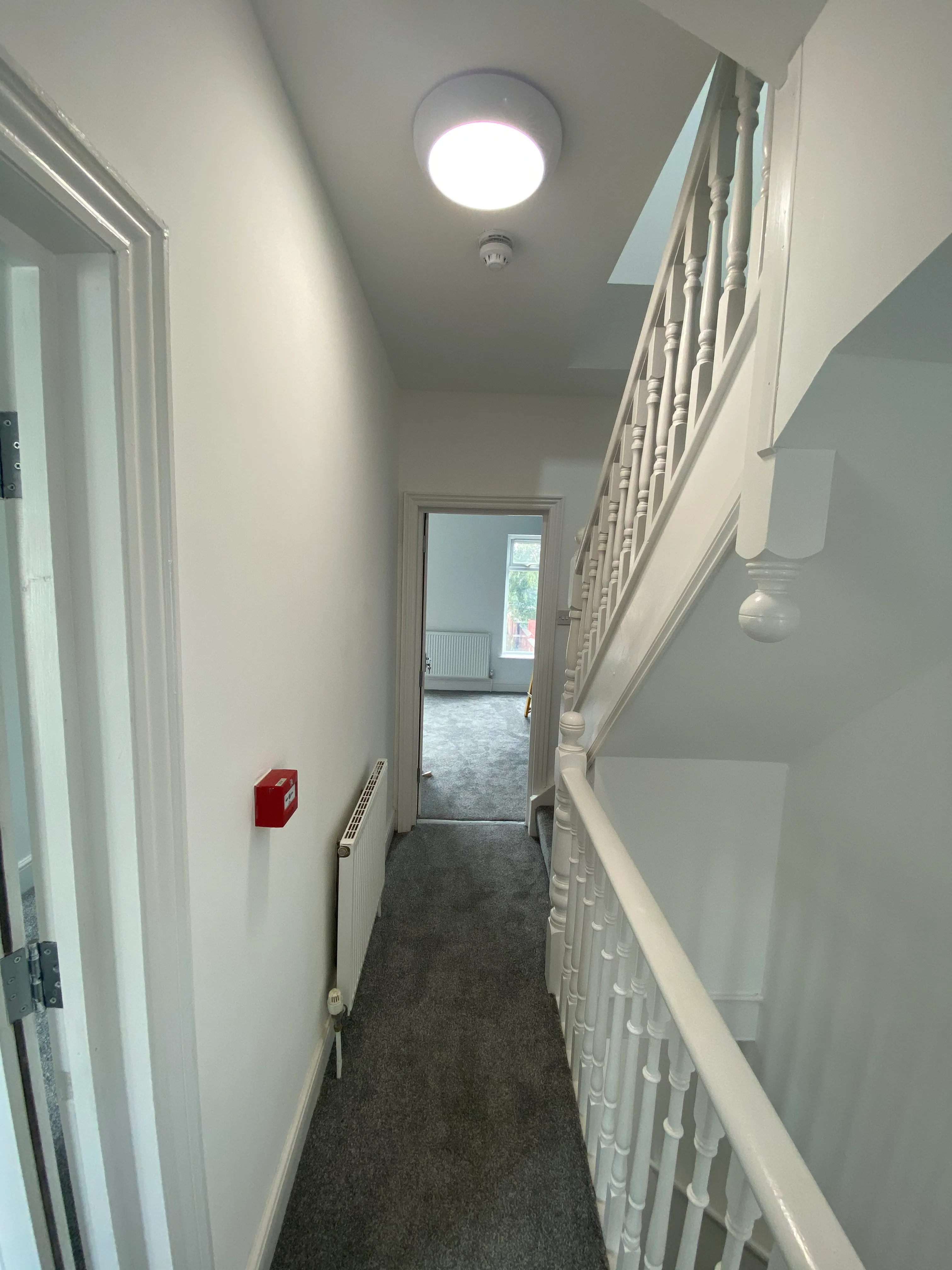 Finished HMO hallway with carpet, lighting and painted staircase